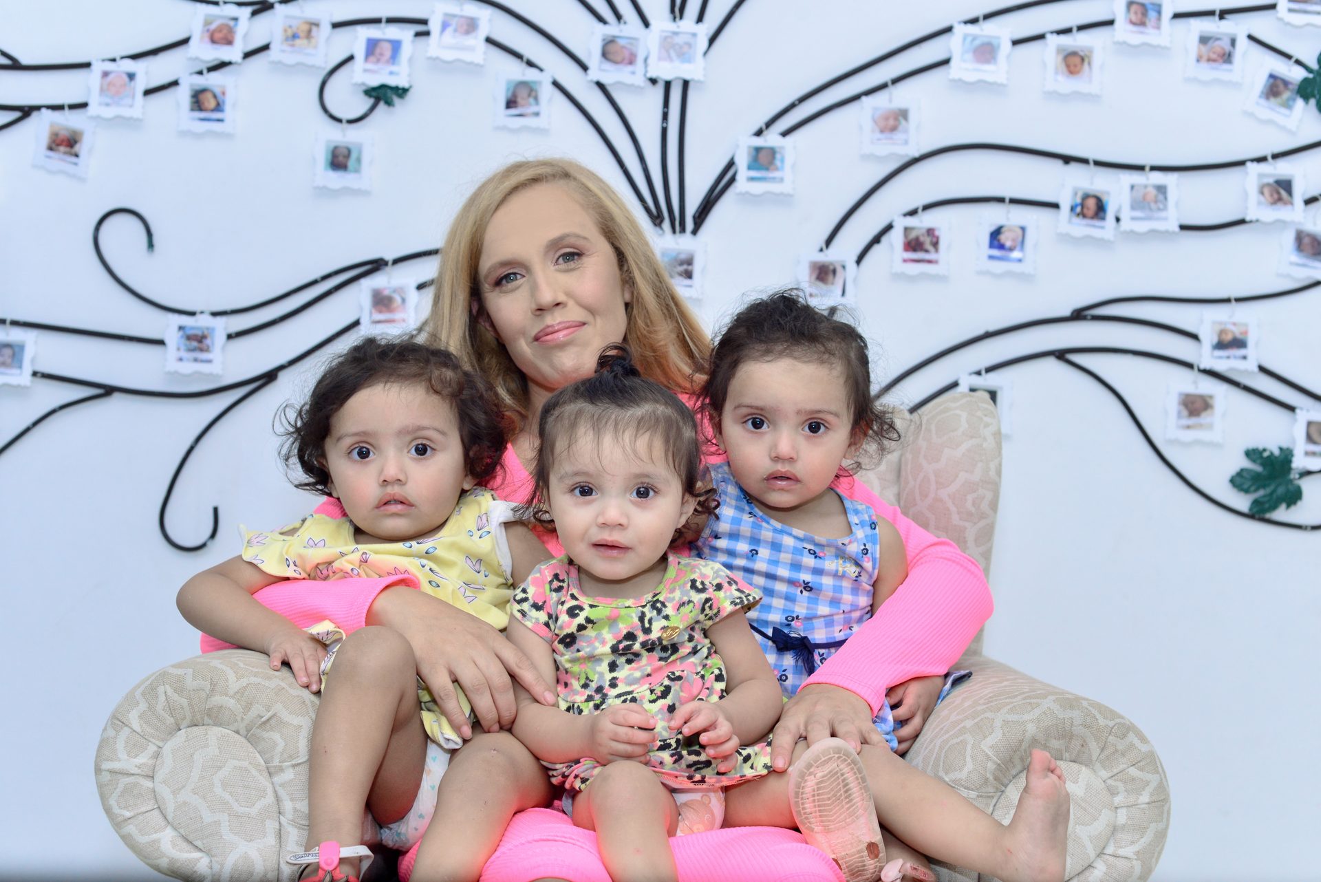 Mãe sorrindo com suas três filhas, atendidas pela Casa Pró-Vida